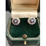 18ct Gold earrings in a Daisey style set with a central diamond surrounded by six blue sapphire