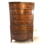 Mahogany bow fronted chest on chest of eight drawers, with turned bun handles, raised on bracket
