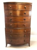 Mahogany bow fronted chest on chest of eight drawers, with turned bun handles, raised on bracket
