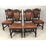 Four antique leather, upholstered ornately carved chairs on castors