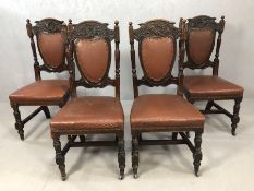 Four antique leather, upholstered ornately carved chairs on castors