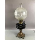 Oil lamp with deep purple central reservoir and etched glass shade and chimney on a brass bass