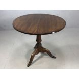 Circular tilt top table on tripod feet with turned central column, approx 74cm in diameter