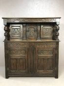 Substantial oak Arts and Crafts court cupboard with extensive carving, with baluster columns,