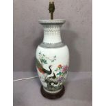 Chinese style ceramic lamp base depicting peacocks, on wooden stand