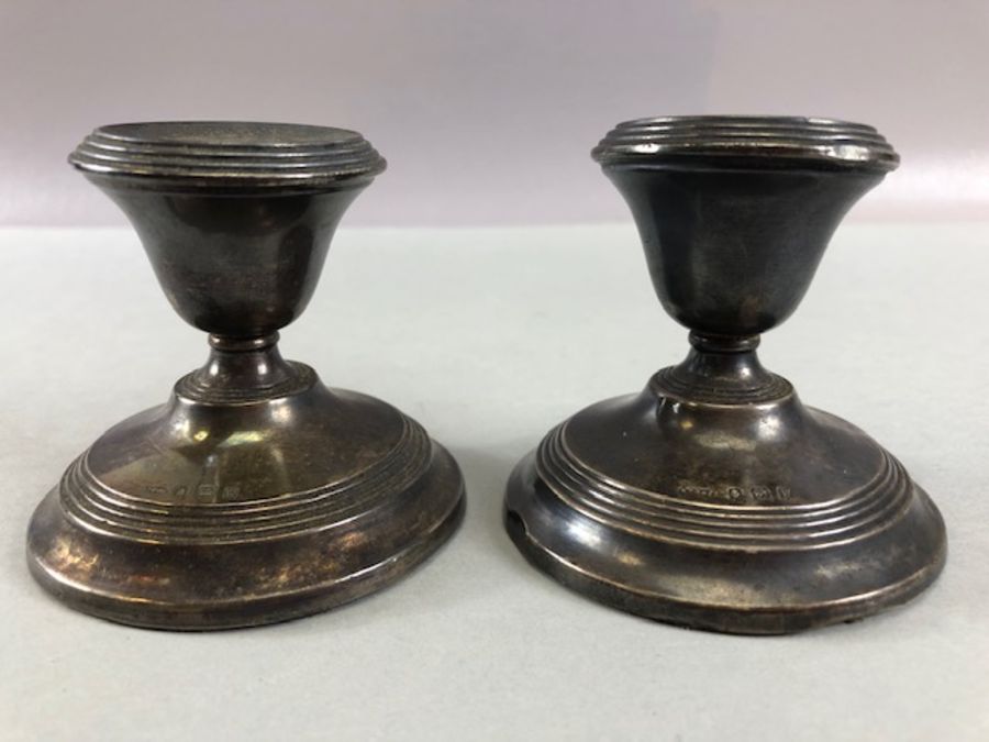 Pair of squat Silver hallmarked candlesticks on circular stepped bases hallmarked for Birmingham