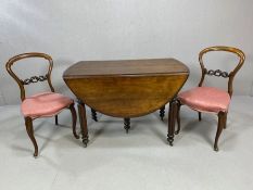 Antique drop leaf extending dining table on turned reeded legs with castors accompanied by two