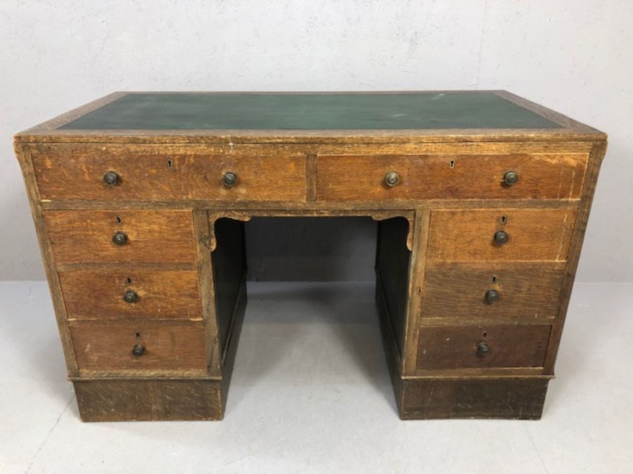 Harvey Nichols 1930s oak twin pedestal kneehole desk with eight drawers and green leather top,