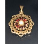 9ct Gold Pendant set with a central Pearl and surrounded by Garnet gemstones approx 20mm in diameter