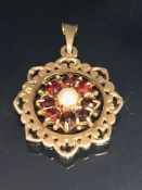 9ct Gold Pendant set with a central Pearl and surrounded by Garnet gemstones approx 20mm in diameter