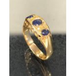 18ct gold three stone sapphire and diamond ring on raised and pierced setting approx size 'O' and