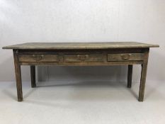 Antique four plank kitchen or scullery table with breadboard ends and three drawers with brass
