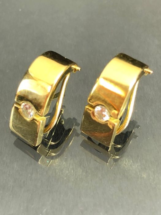 Pair of unmarked Gold earrings each set with a single Diamond in a contemporary style (total