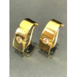 Pair of unmarked Gold earrings each set with a single Diamond in a contemporary style (total