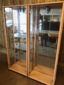 Pair of tall, lockable glass display cabinets, with glass shelves, keys and internal lights, each