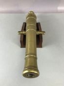 Brass metal cannon approx 34cm long on a wooden plinth