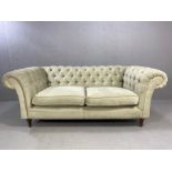 Chesterfield style two seater sofa upholstered in light grey fabric, approx 195cm x 100cm x 78cm