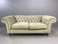 Chesterfield style two seater sofa upholstered in light grey fabric, approx 195cm x 100cm x 78cm