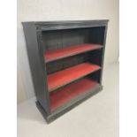 Ebonised black Victorian bookcase on plinth with two red lined shelves and fluted detailing approx