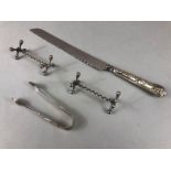 Silver handled Bread knife, a silver hallmarked pair of sugar nips with a pair of knife rests