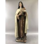 Painted plaster sculpture of the Virgin Mary holding a crucifix and flowers on a square plinth
