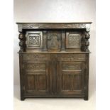 Substantial oak Arts and Crafts court cupboard with extensive carving, with baluster columns,