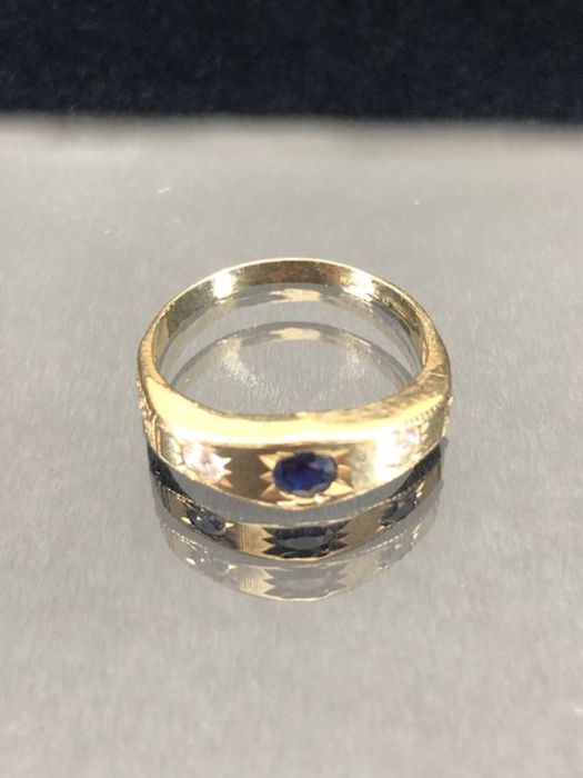 9ct Gold ring set with a blue sapphire in a star shaped mount with two Diamonds to either side - Image 3 of 7