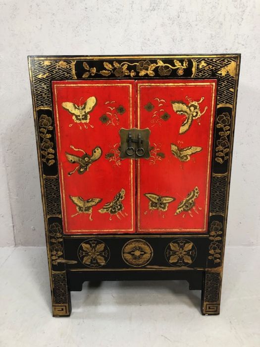 Chinoiserie-style cupboard, in black with gilt and red decoration and butterfly motifs, approx