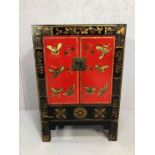 Chinoiserie-style cupboard, in black with gilt and red decoration and butterfly motifs, approx