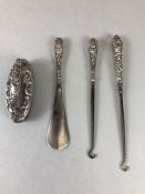 Collection of silver handled fully hallmarked items to include button hooks, nail buffer, and shoe