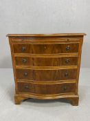 Serpentine fronted reproduction chest of four drawers with fluted sides and metal circular