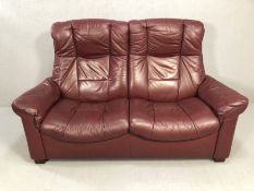 Leather two seater reclining sofa in burgundy, approx 160cm wide