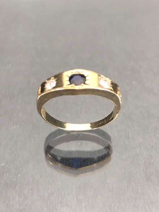 9ct Gold ring set with a blue sapphire in a star shaped mount with two Diamonds to either side