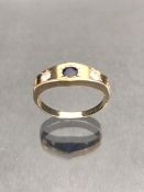 9ct Gold ring set with a blue sapphire in a star shaped mount with two Diamonds to either side