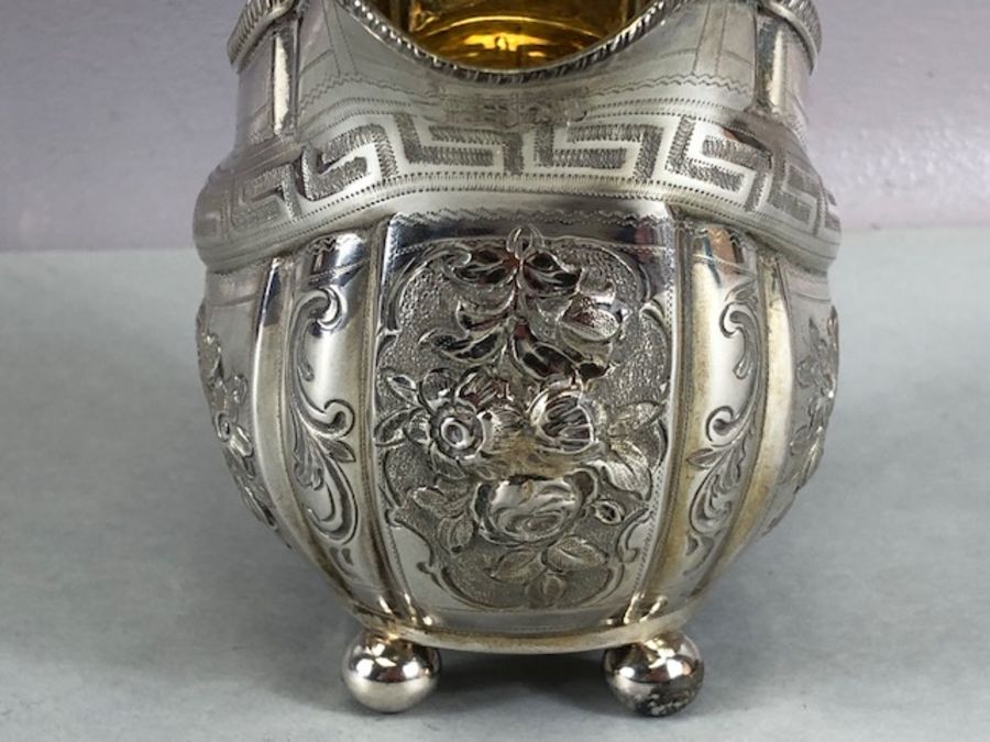 Silver hallmarked jug on four bun feet with gold gilt interior and repoussé floral decoration - Image 7 of 12