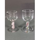 Two firing glasses with twisted coloured design to stems, one with etched Masonic symbol to bowl and