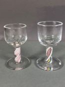 Two firing glasses with twisted coloured design to stems, one with etched Masonic symbol to bowl and