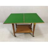 Mid Century card table, with fold-out baize, shelf under, on castors