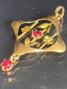 9ct Gold pendant in the Art Nouveau style with gold flowers and set with red gemstones