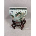 Ornamental chinese fish bowl/plant pot on carved wooden stand