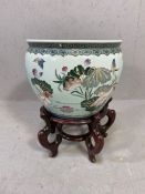 Ornamental chinese fish bowl/plant pot on carved wooden stand
