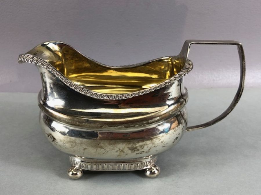 Silver Hallmarked Georgian milk jug on four bun feet with gold gilt interior hallmarked for Exeter