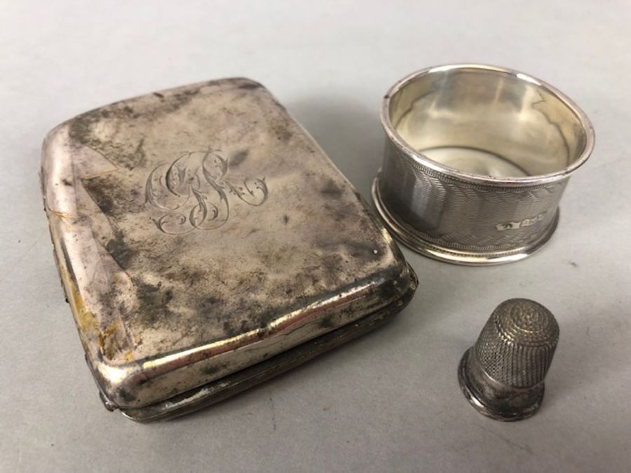 Silver items to include cigarette case (A/F) thimble and a napkin ring (80g)