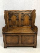 Heavily carved two panelled oak hall seat with linen fold design and seat lid opening to reveal
