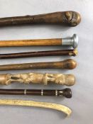 Collection of seven walking sticks, one with mother of pearl inlay another with the handle inscribed