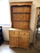 Pine kitchen dresser with two drawers and cupboards under. Two shelves above and brass coloured