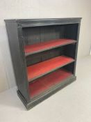 Ebonised black Victorian bookcase on plinth with two red lined shelves and fluted detailing approx