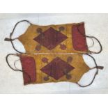 Two North African saddle bags, one of woven carpet, the other with painted geometric designs on