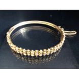 9ct Rose Gold Bangle decorated with Gold bars with good catch and safety chain approx 10g