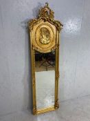 Large gilt framed oblong mirror, the frame depicting a woman's head, approx 47cm x 179cm (A/F)
